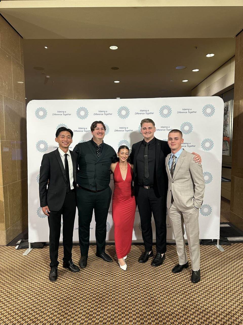 Five team members dressed up at an evening event