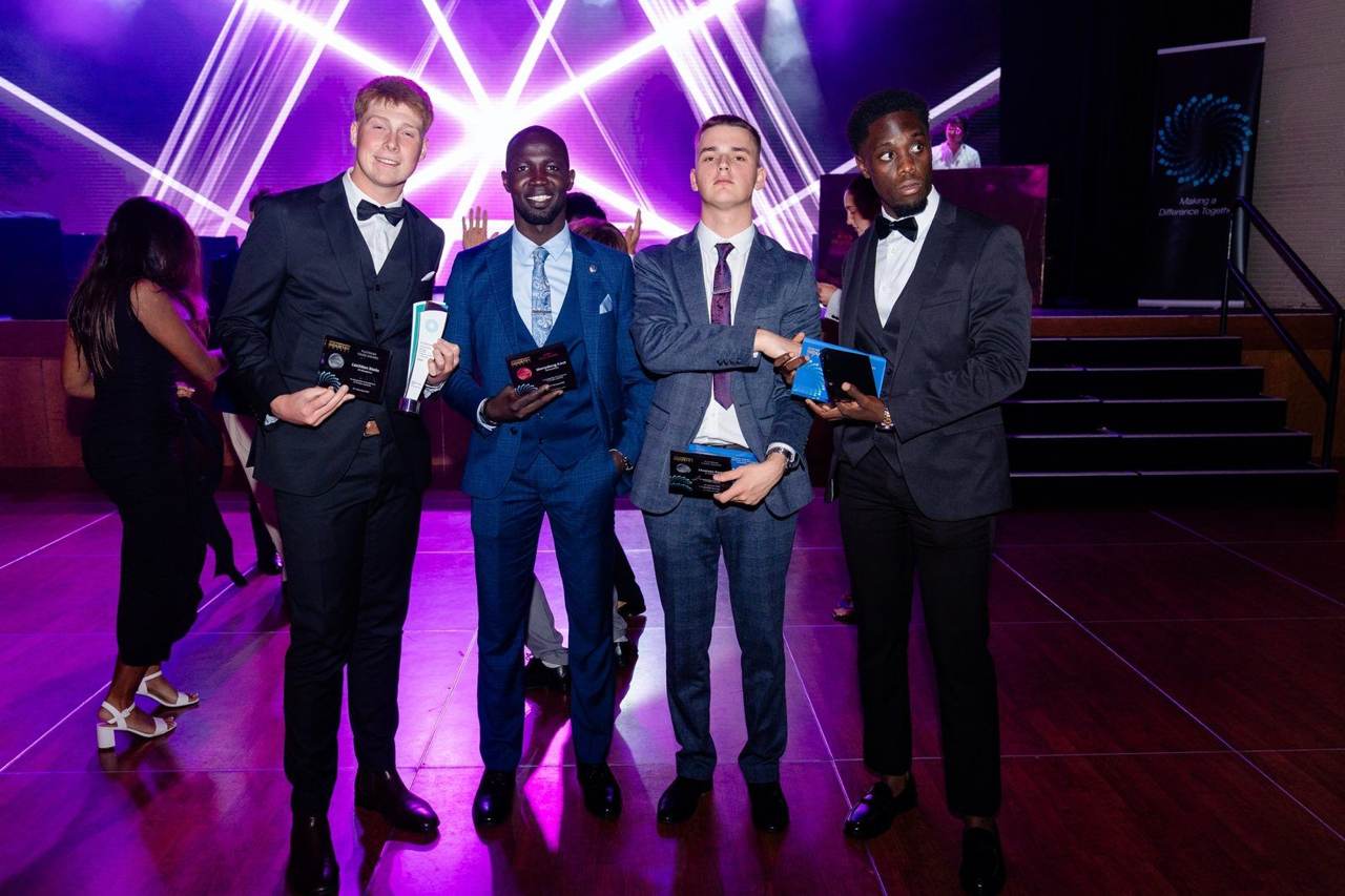 Four team members with their awards