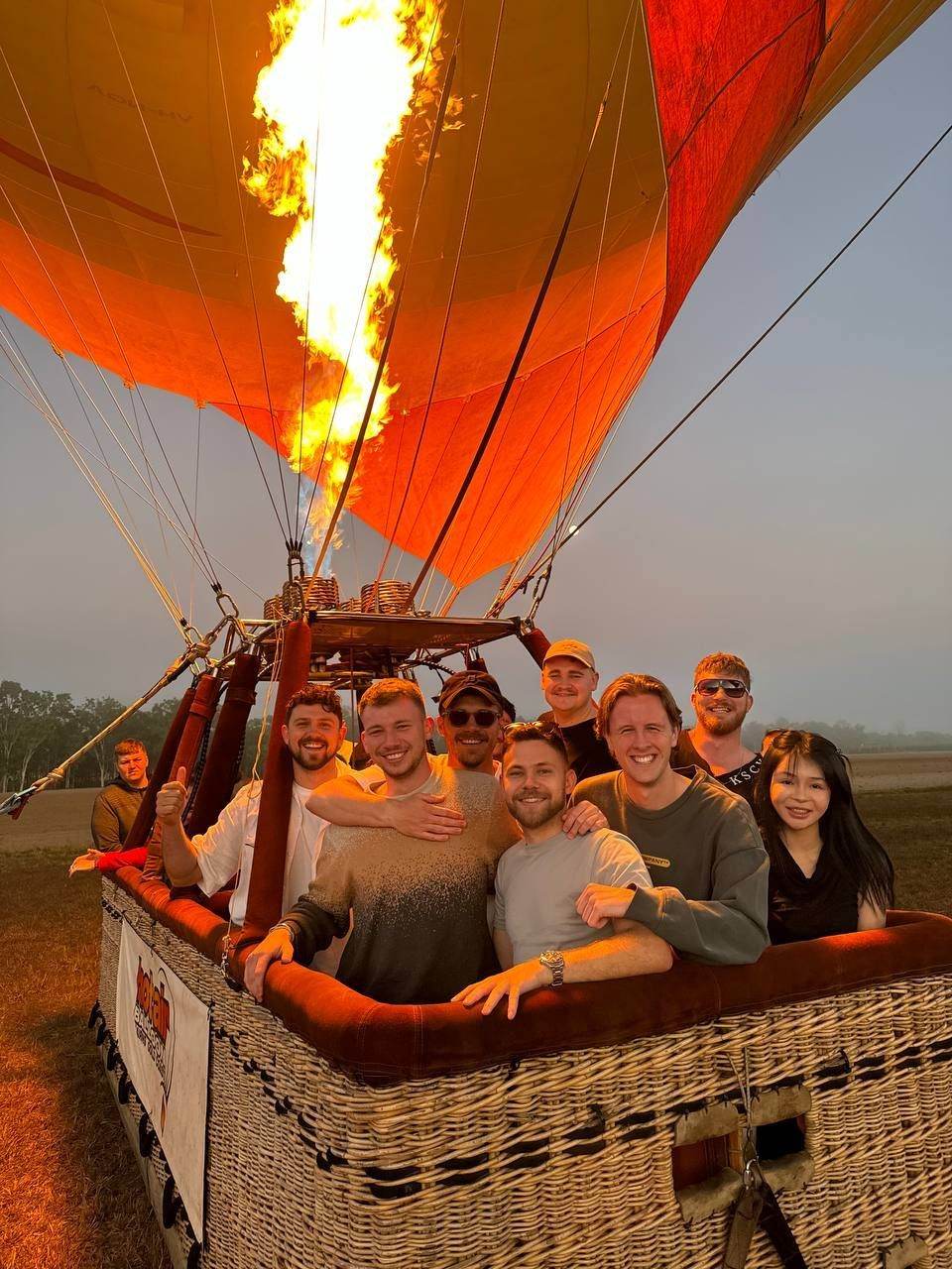 Team in a hot air balloon basket as the burner fires