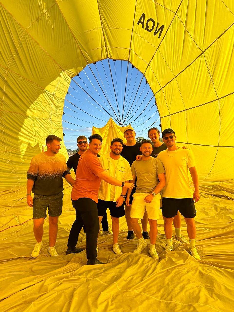 Team standing inside a yellow hot air balloon