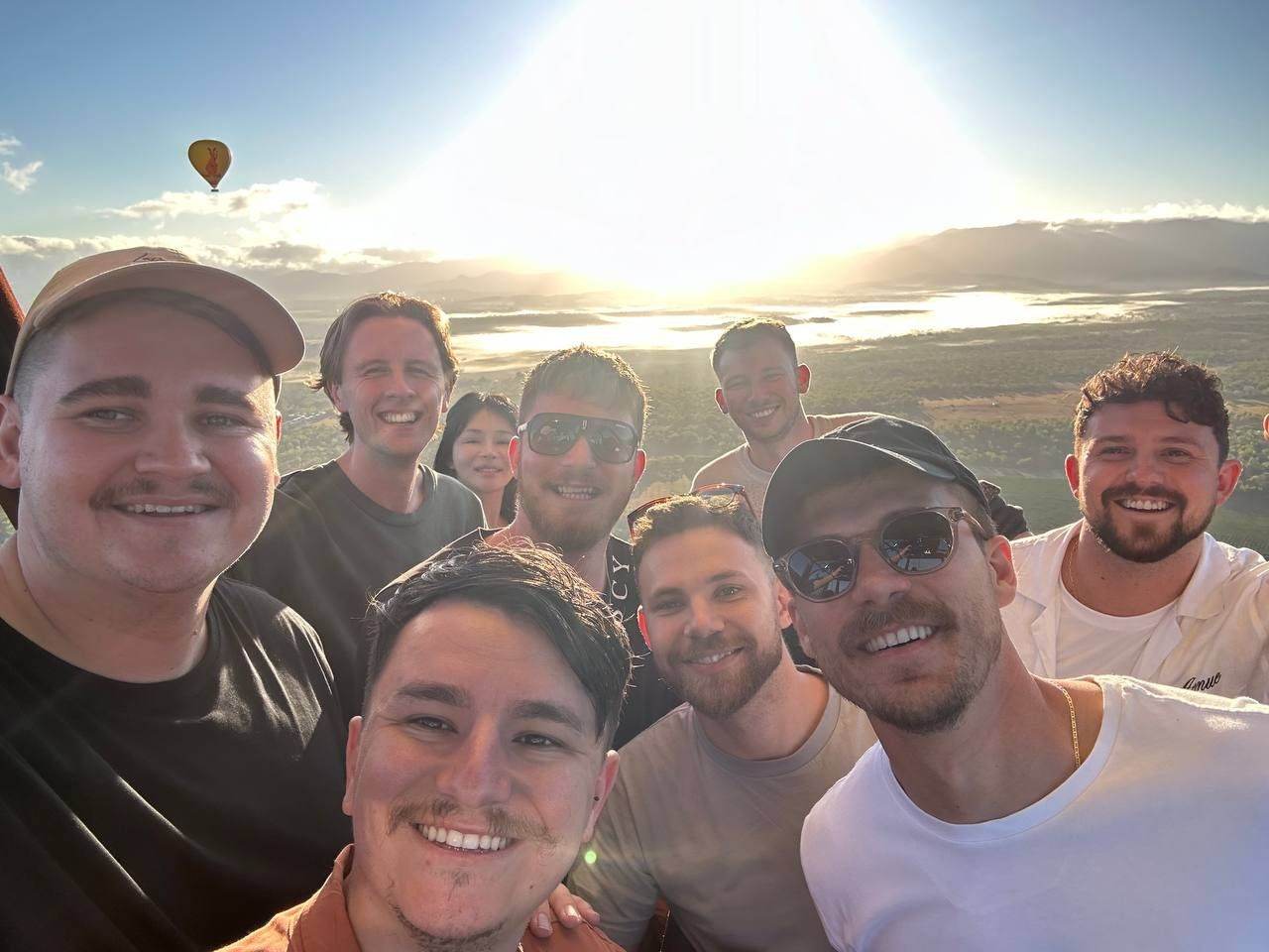 Team selfie from a hot air balloon at sunrise