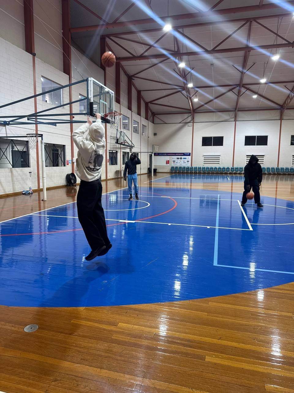 Team shooting hoops at an indoor court