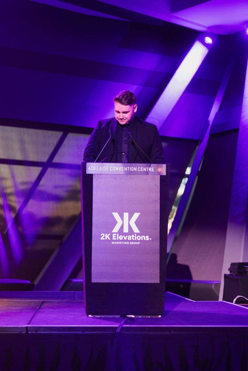 Elijah speaking at the podium at the Adelaide Convention Centre