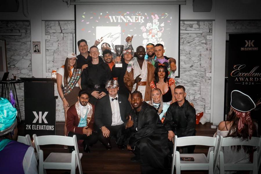 The Minear Group team in costume holding the winner's trophy