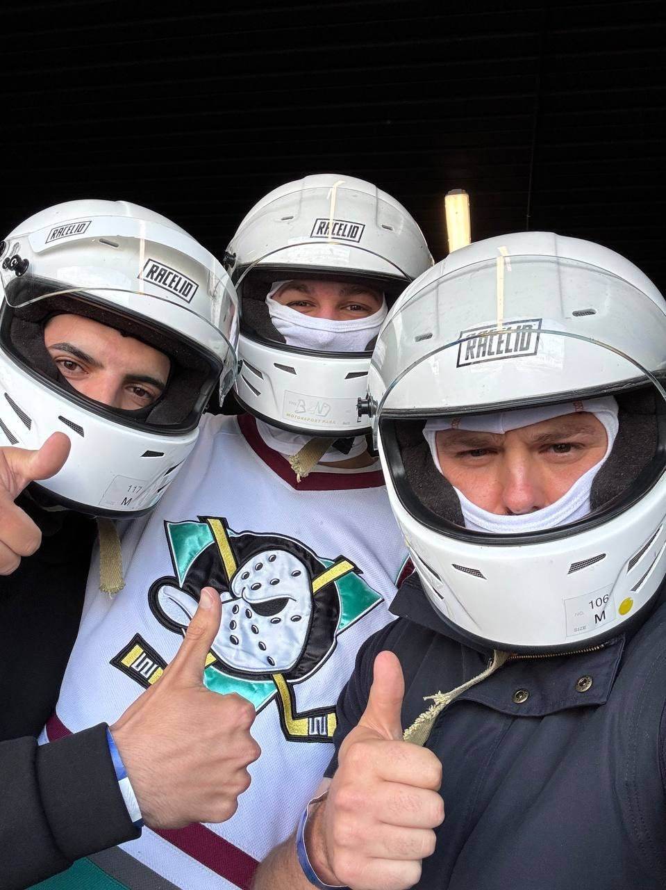 Three team members in racing helmets