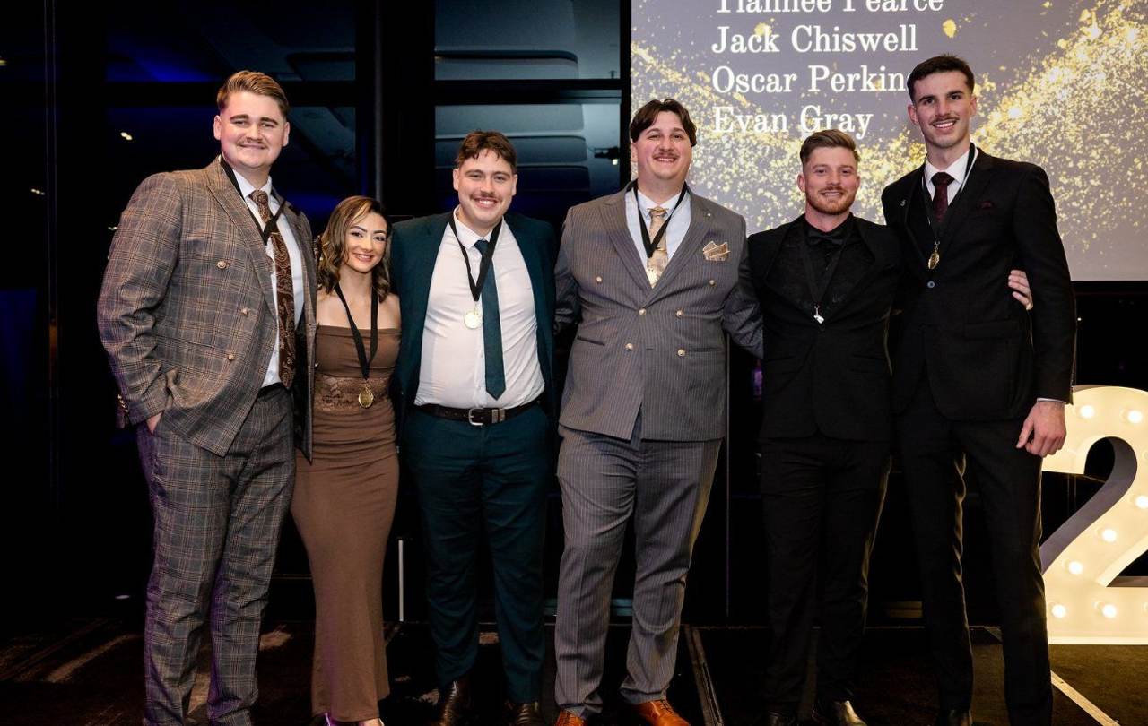 Team members wearing medals on stage