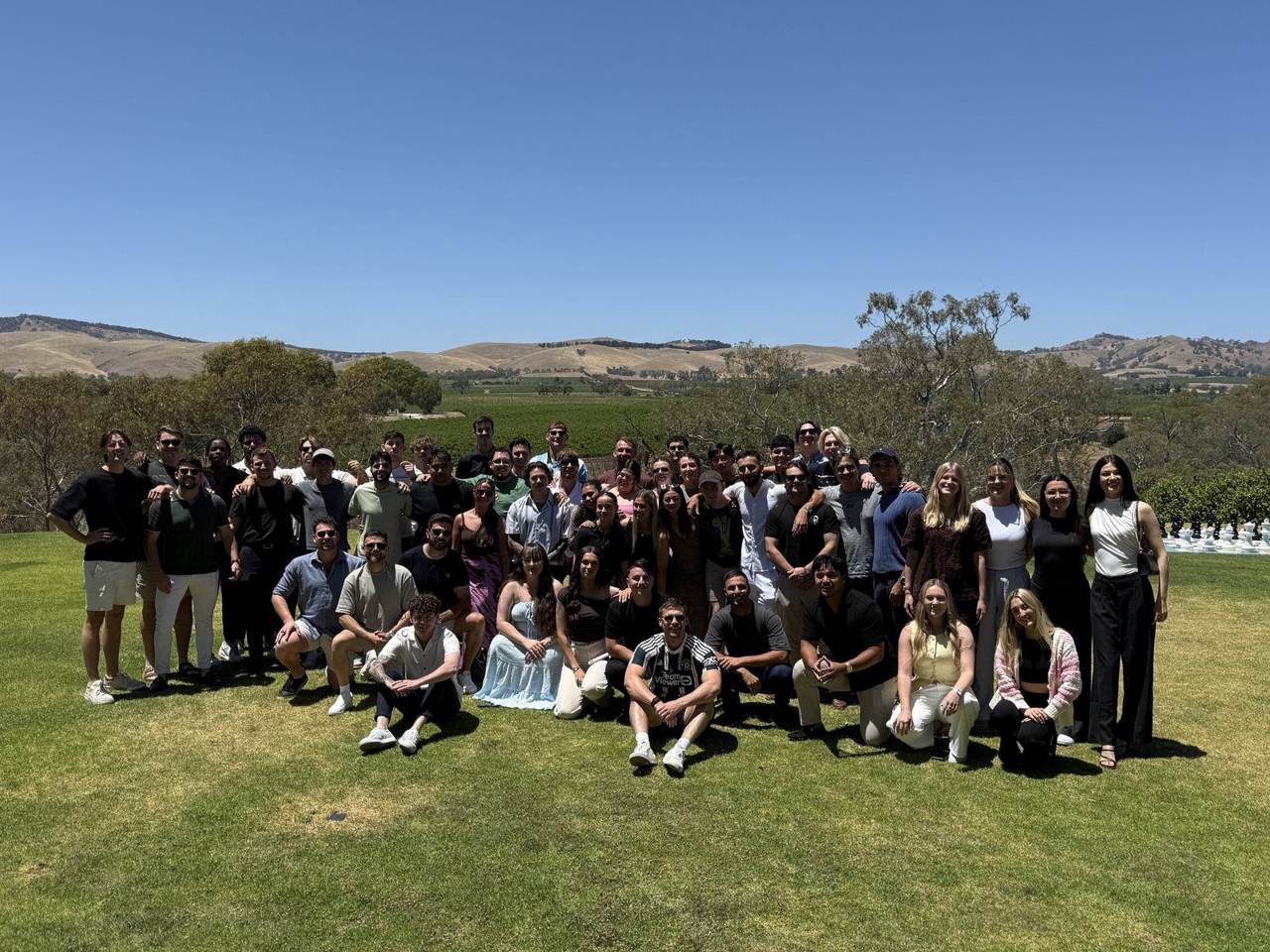 The whole team together at a winery in the hills